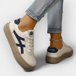 Platform retro sneakers, white with navy stripes, tan thick sole and lace-up closure.