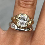 Gold and silver-tone ring set with square-cut clear stones on stacked bands