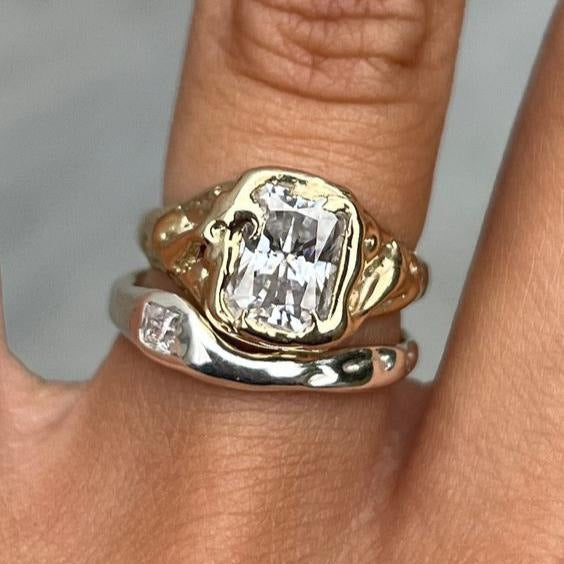 Gold and silver-tone ring set with square-cut clear stones on stacked bands