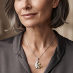 Hugging cat pendant necklace on woman, silver chain with cat-hug charm and gold accent