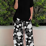 Isolde two-piece set: black blouse with short sleeves and black floral wide-leg pants