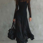 Long black dress with fitted bodice, sheer sleeves, and draped layered hem
