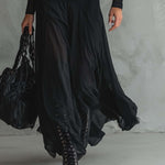 Long black dress with flowing layered skirt and sheer sleeve cuffs