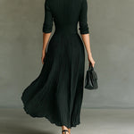 Long dark green pleated dress, back view, fitted high waist and 3/4 sleeves