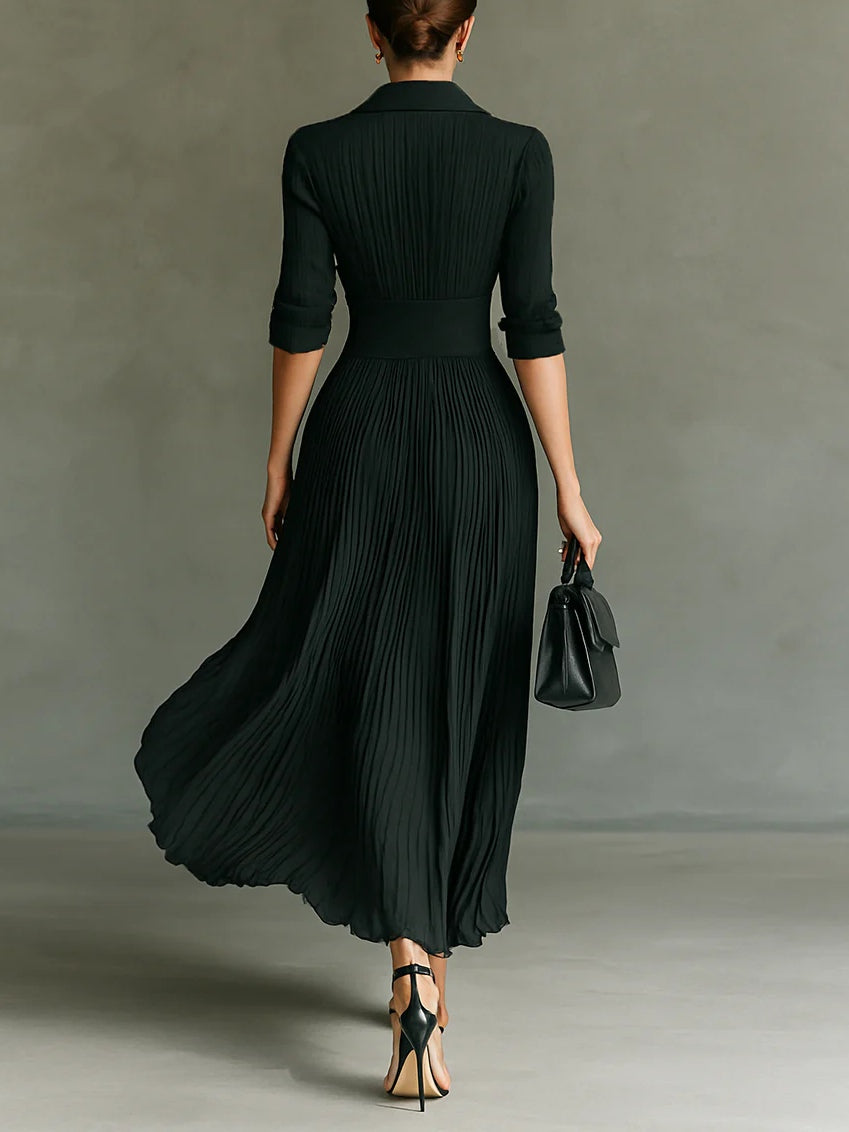 Long dark green pleated dress with lapel collar, fitted waist, and 3/4 sleeves