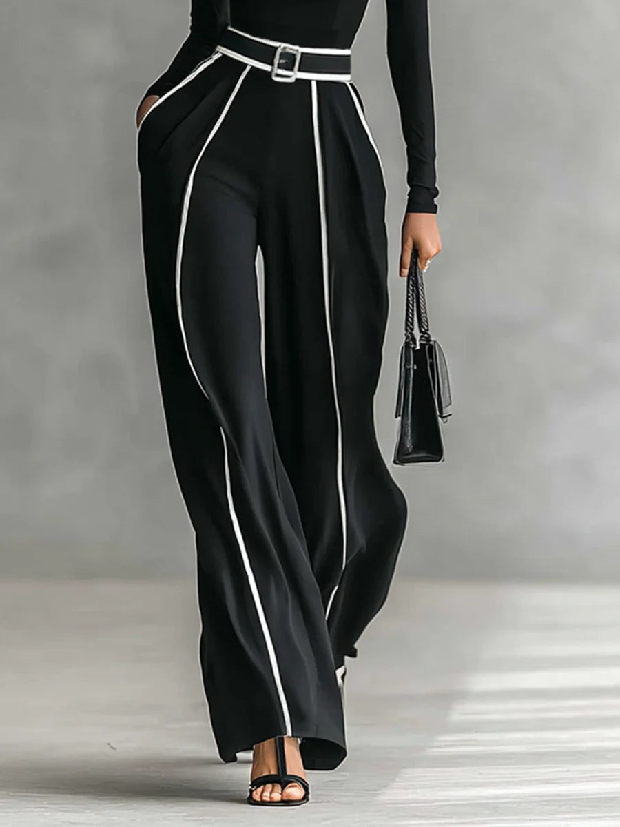 Black wide-leg jumpsuit with high neck, belt buckle, and contrast vertical piping