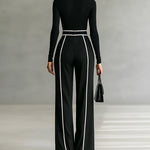 Black high-neck wide-leg jumpsuit, sleeved back view with vertical piping and belt