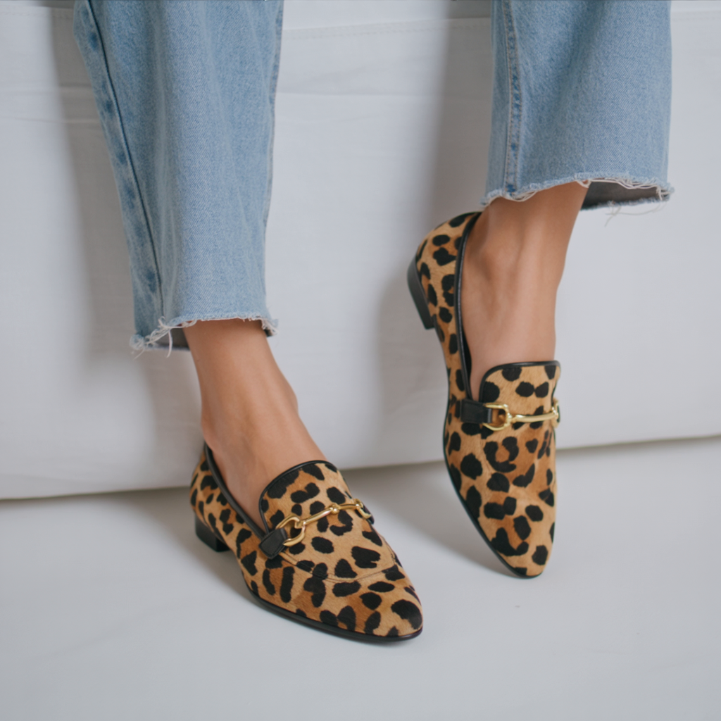 Leopard print moccasin loafers with gold buckle strap, low flat sole.
