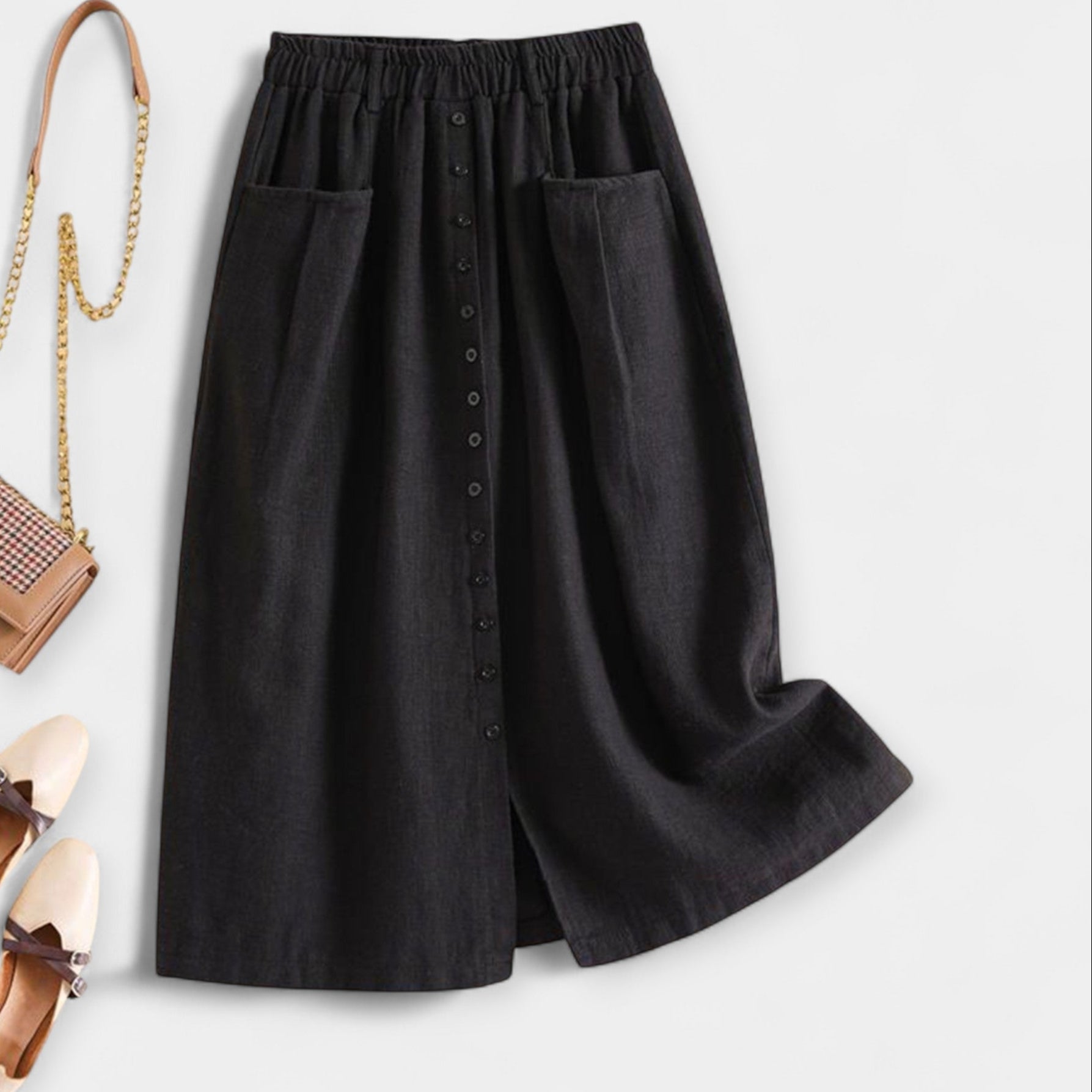 Black midi skirt with elastic waistband, front buttons, and side pockets.