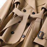 Beige trench coat close-up of black buttons and waist belt with buckle