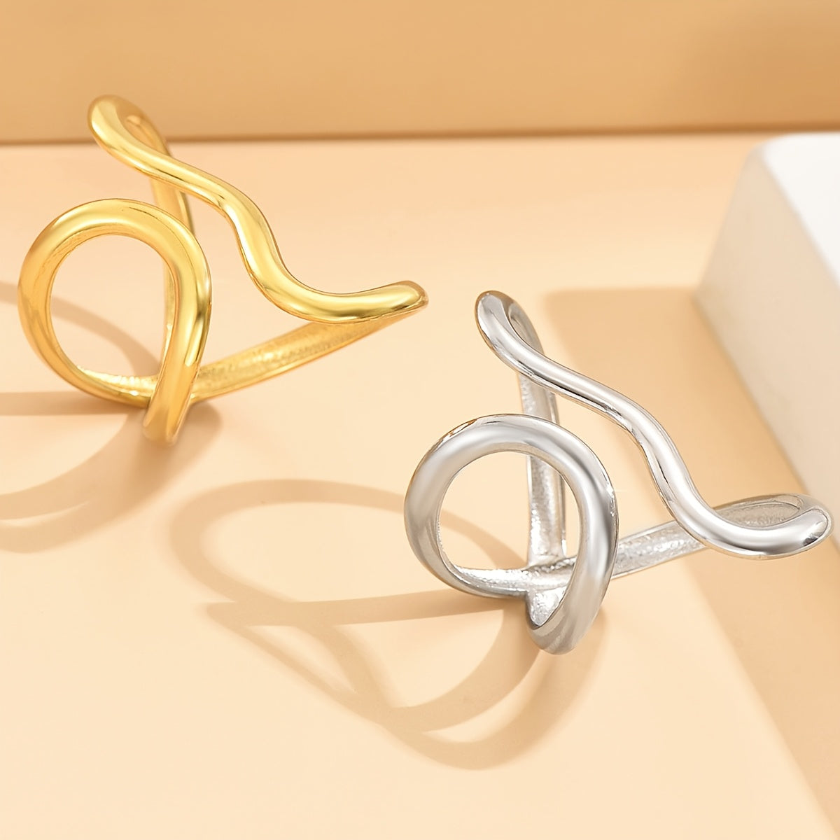 Gold- and silver-tone asymmetric wave rings with curled open-loop designs