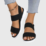 Black orthopedic slide sandal with wide textured straps, open toe, white cushioned sole
