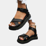Black comfort sandals with two straps and buckle, chunky sole with yellow stitching