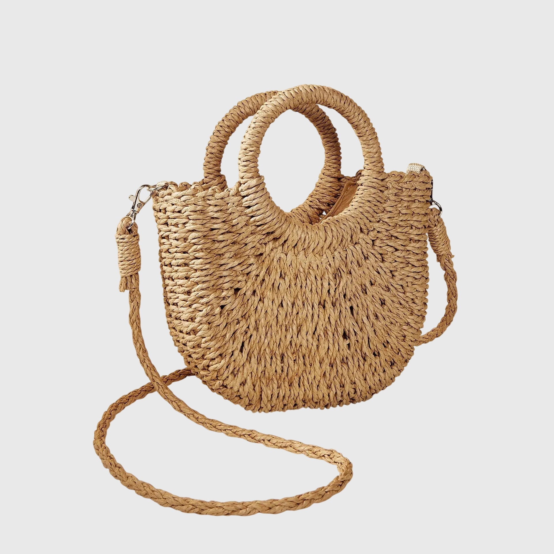 Khaki-beige woven straw shoulder bag with ring handles and long braided crossbody strap.