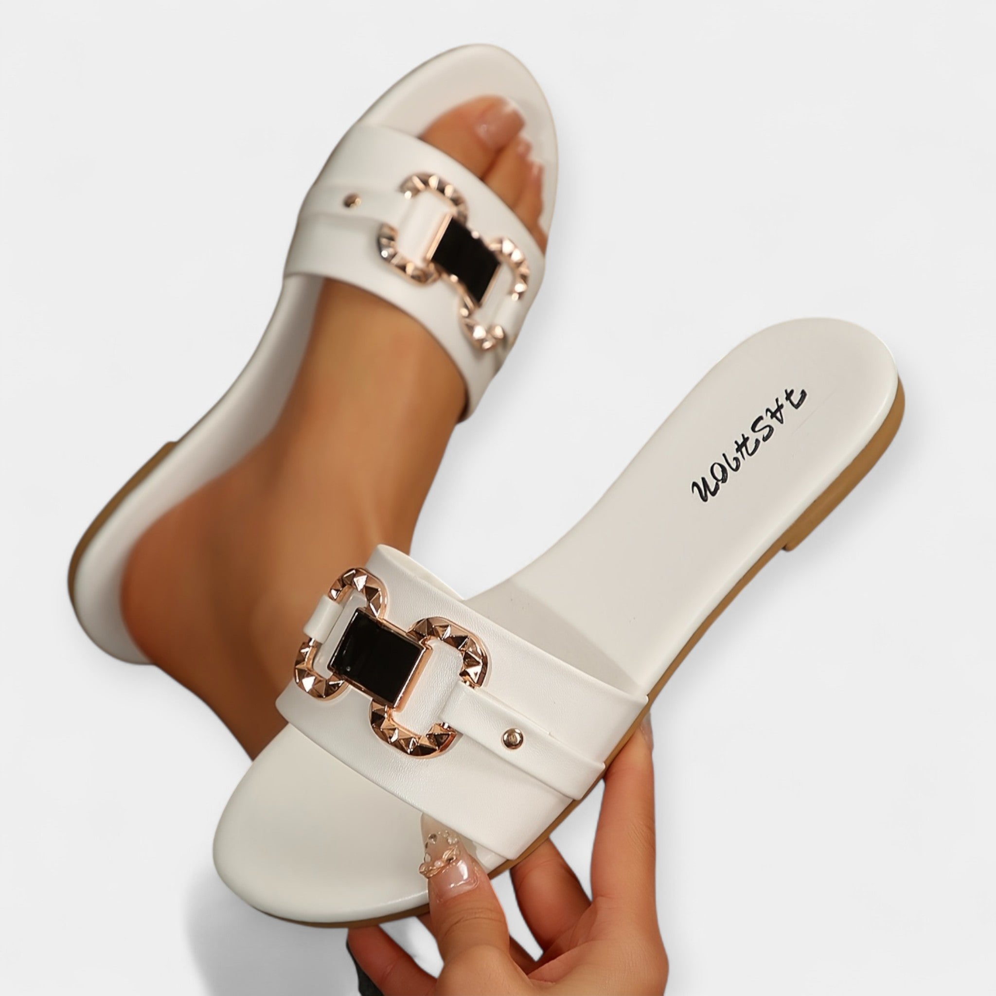 White slide sandals with round toe, wide buckled straps, flat comfort sole