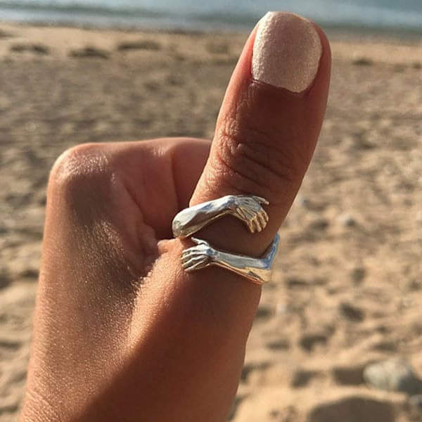 Adjustable silver hug ring with clasped hands motif