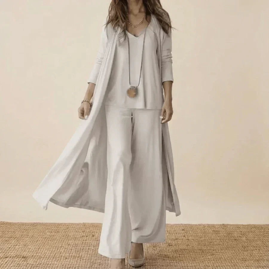 White 3-piece set with long duster, tunic top, and wide-leg trousers.