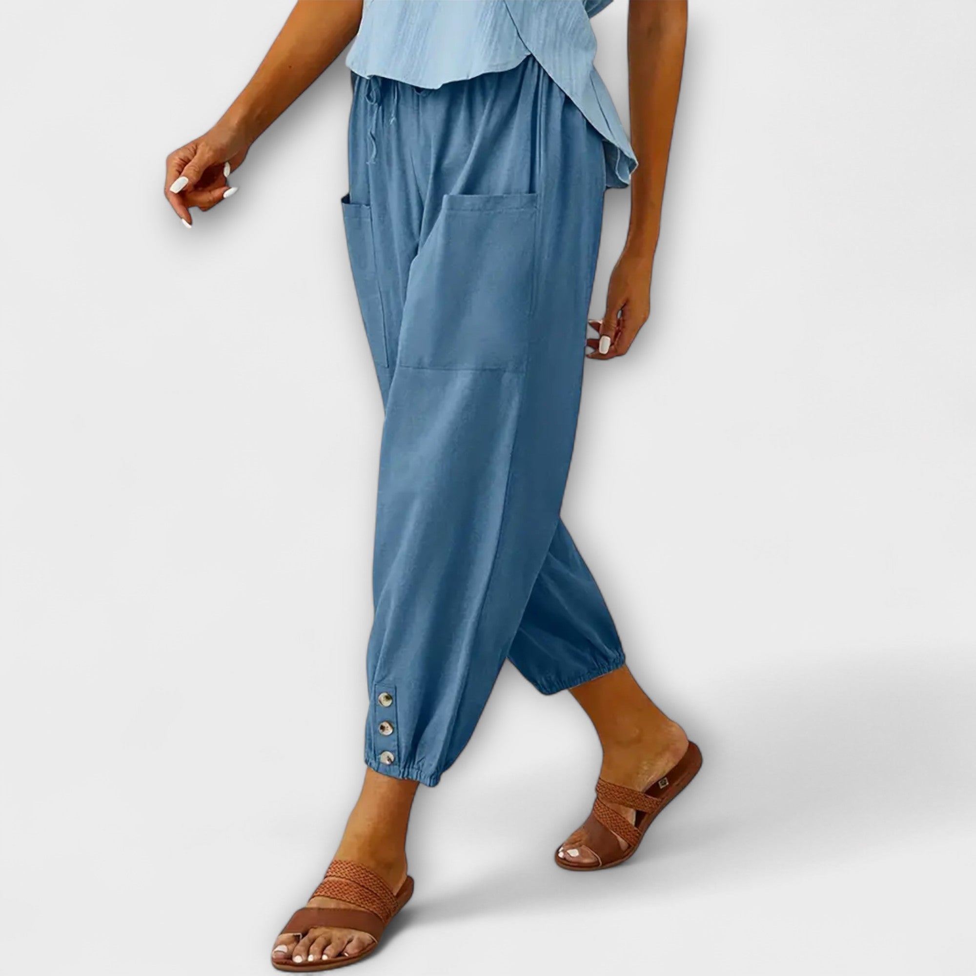 Light blue harem pants with side pockets and button-tab cuffs, relaxed loose fit
