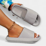 Gray slide sandals with wide strap, open toe, and cushioned textured sole