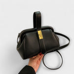 Black textured leather vintage-style crossbody bag with gold front clasp
