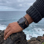 Black multi-wrap Apple Watch bracelet with volcanic stone beads and stainless steel closure