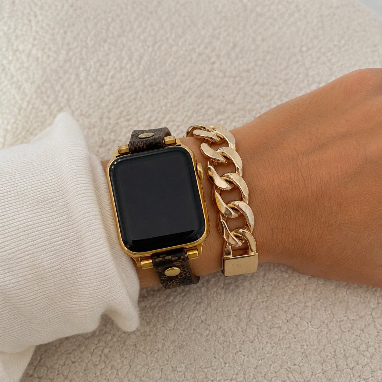 Brown patterned Apple Watch band with gold Cuban-link chain and adjustable clasp
