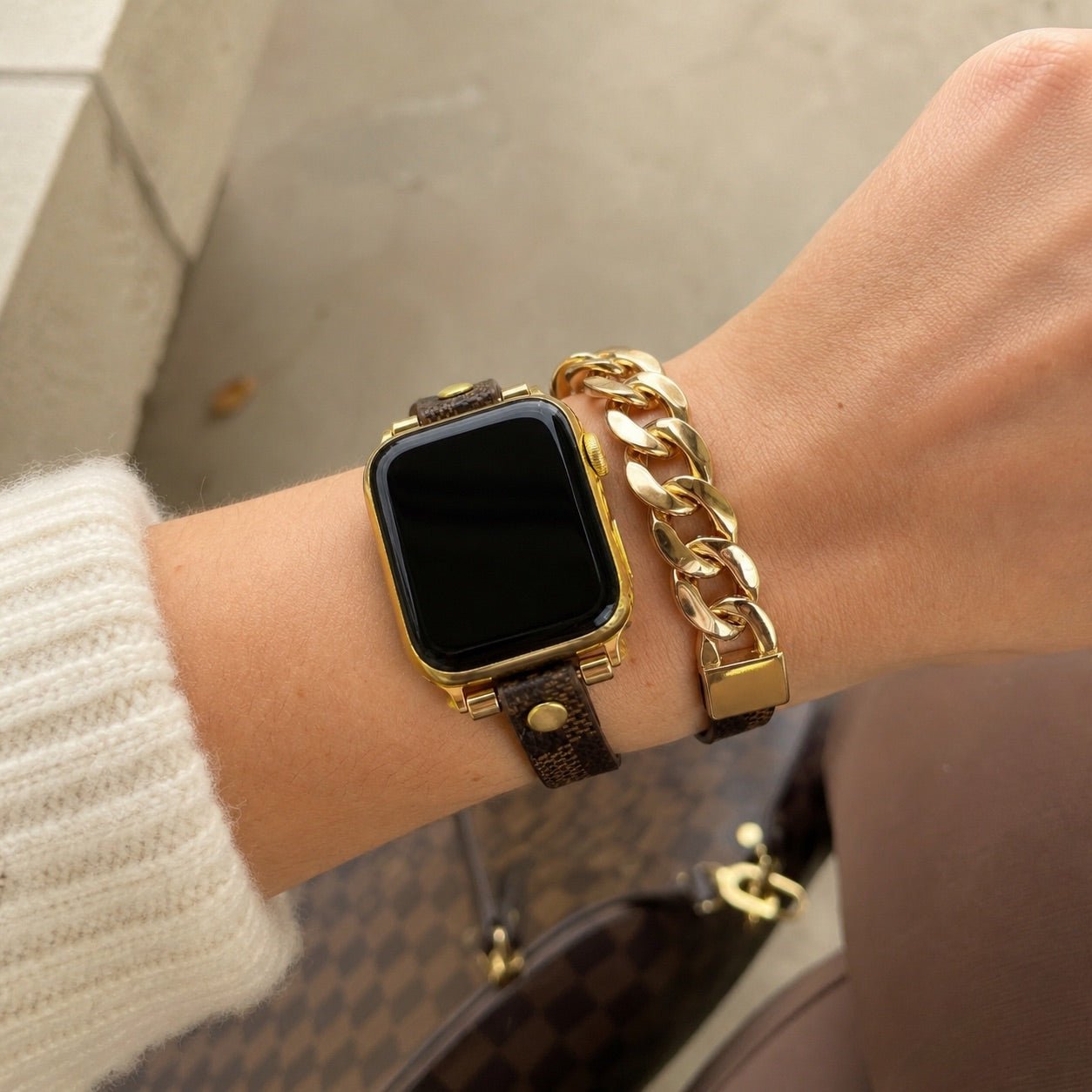 Brown patterned double-wrap Apple Watch strap with gold chain links on wrist