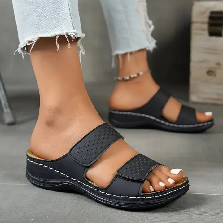 Black orthopedic slide sandals with perforated straps and cushioned footbed