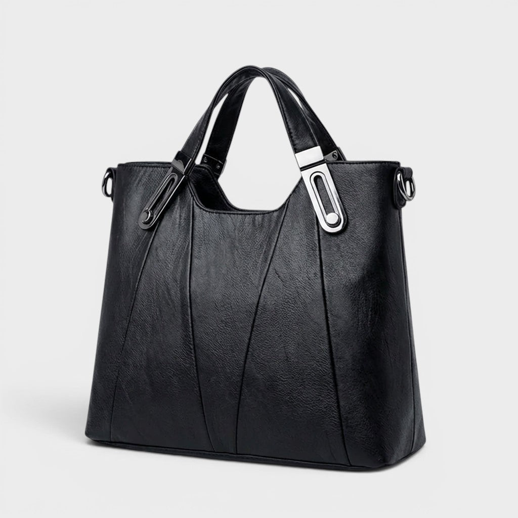 Black leather handbag with top handles, front seam panels, and shoulder strap