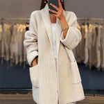 Cream knit cardigan with shawl collar, long sleeves and front patch pockets