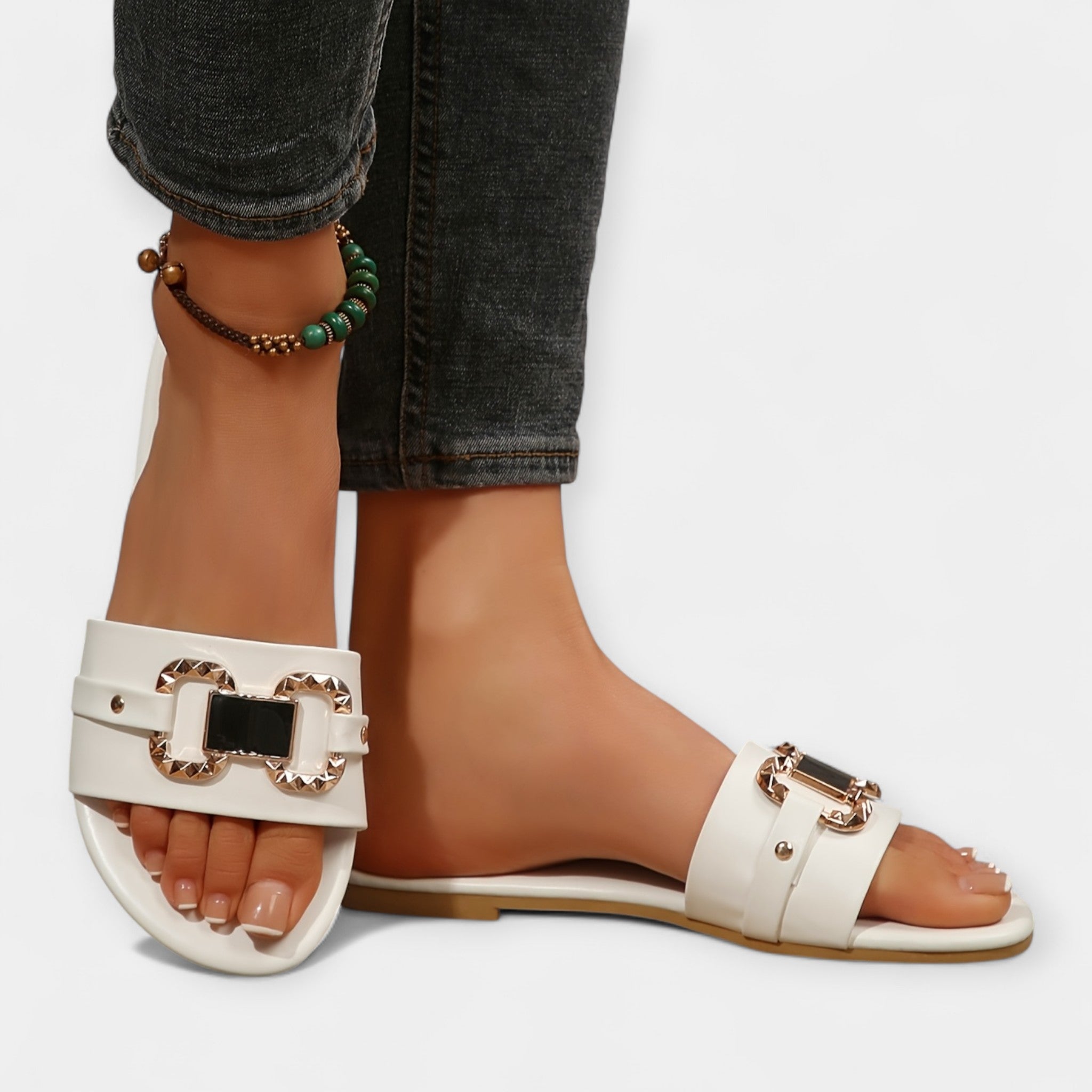 White comfort slide sandals with round toe, wide buckle straps and gold hardware