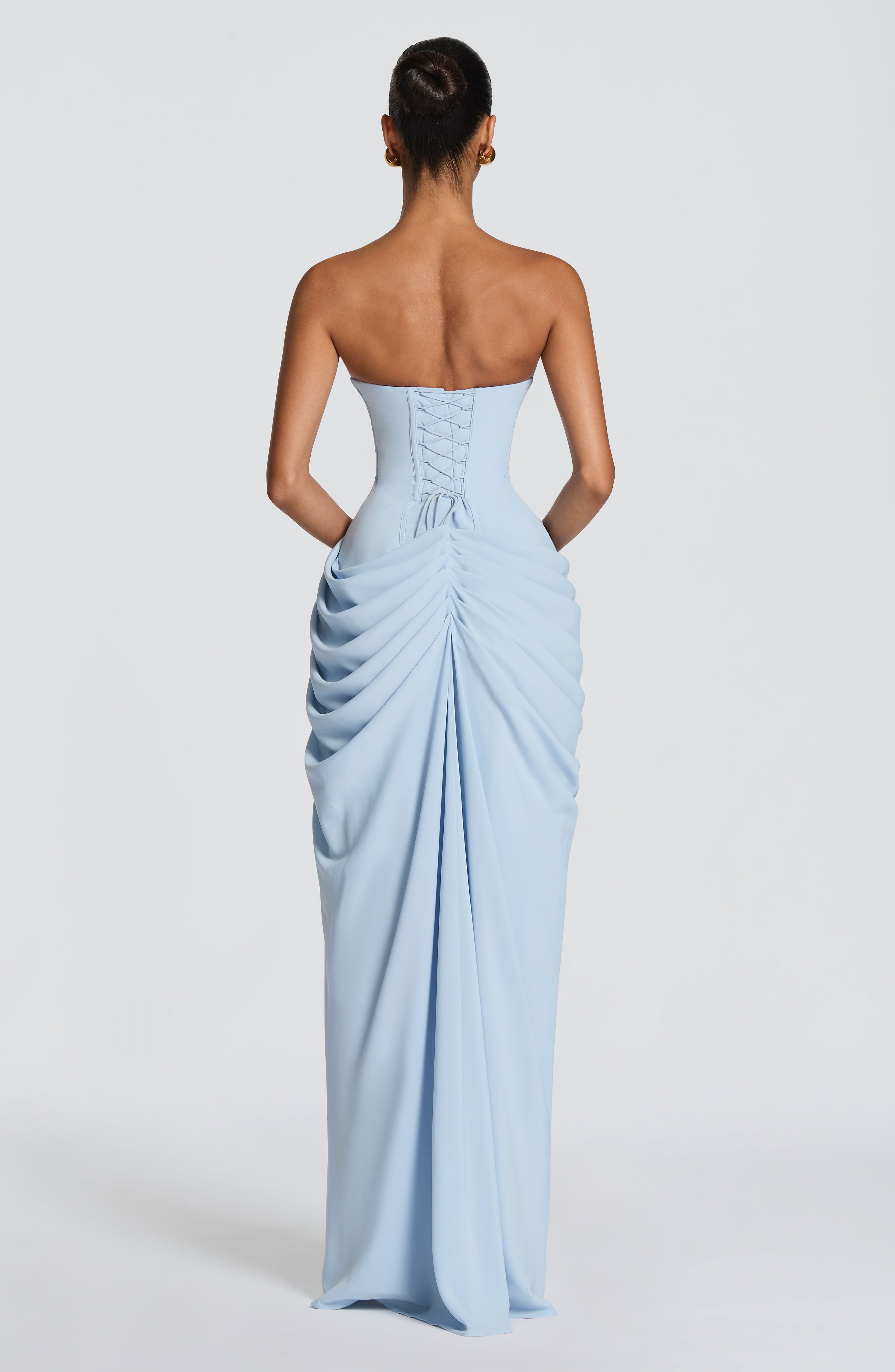 Back view of light blue strapless corset maxi dress with gathered drape