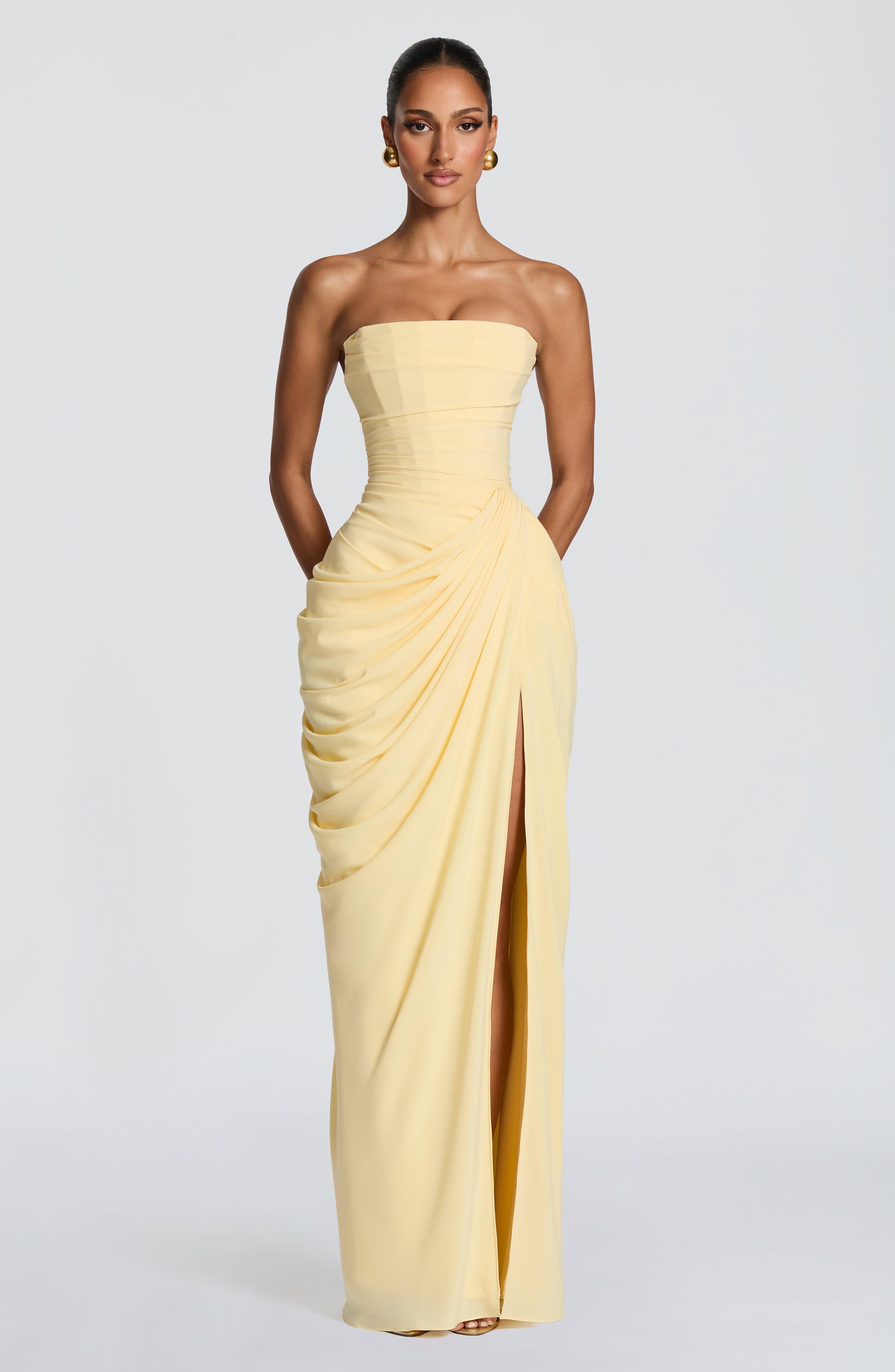 Strapless pale yellow corset maxi dress with side draping and center front slit