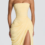 Close-up of pale yellow strapless corset maxi dress with ruched drape and front slit