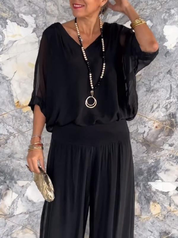 Two-piece chiffon set with V-neck blouse and tiered wide-leg pants, black.
