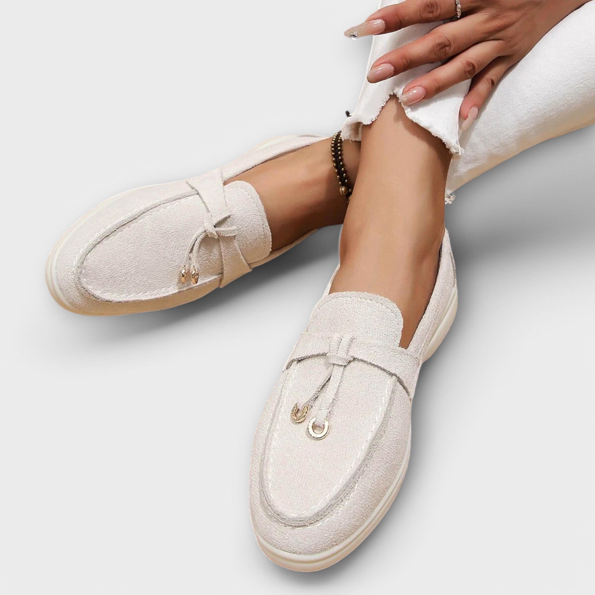 Nefeli beige suede moccasins with tassel accent and fringe edge, close-up