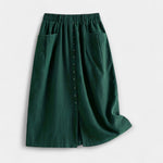 Dark green midi skirt with elastic waistband, front buttons, and side pockets.