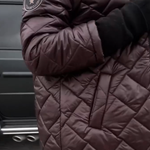 Hooded puffer coat sleeve, dark plum, circular patch on upper arm