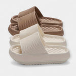Tan and white textured slide sandals with wide strap and thick cushioned sole