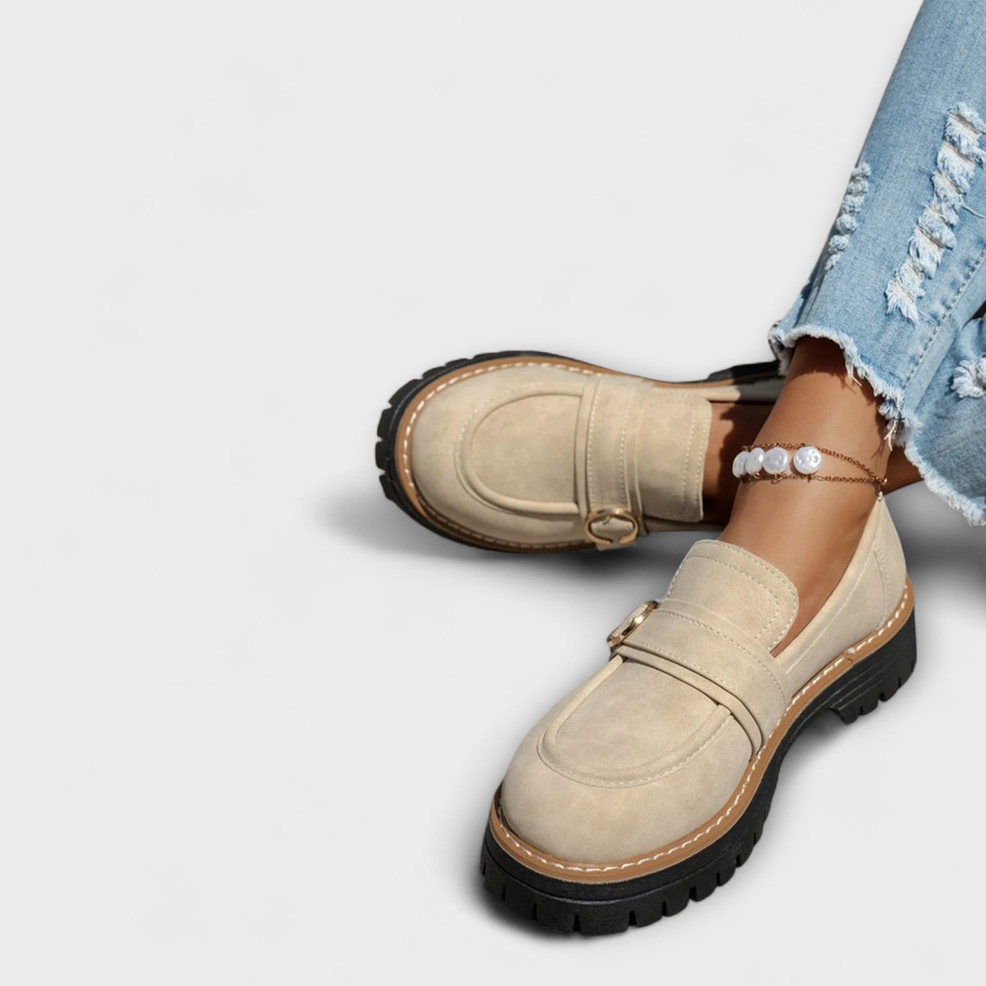 Beige suede moccasin loafers with round toe, metal ring strap, and lug tread sole