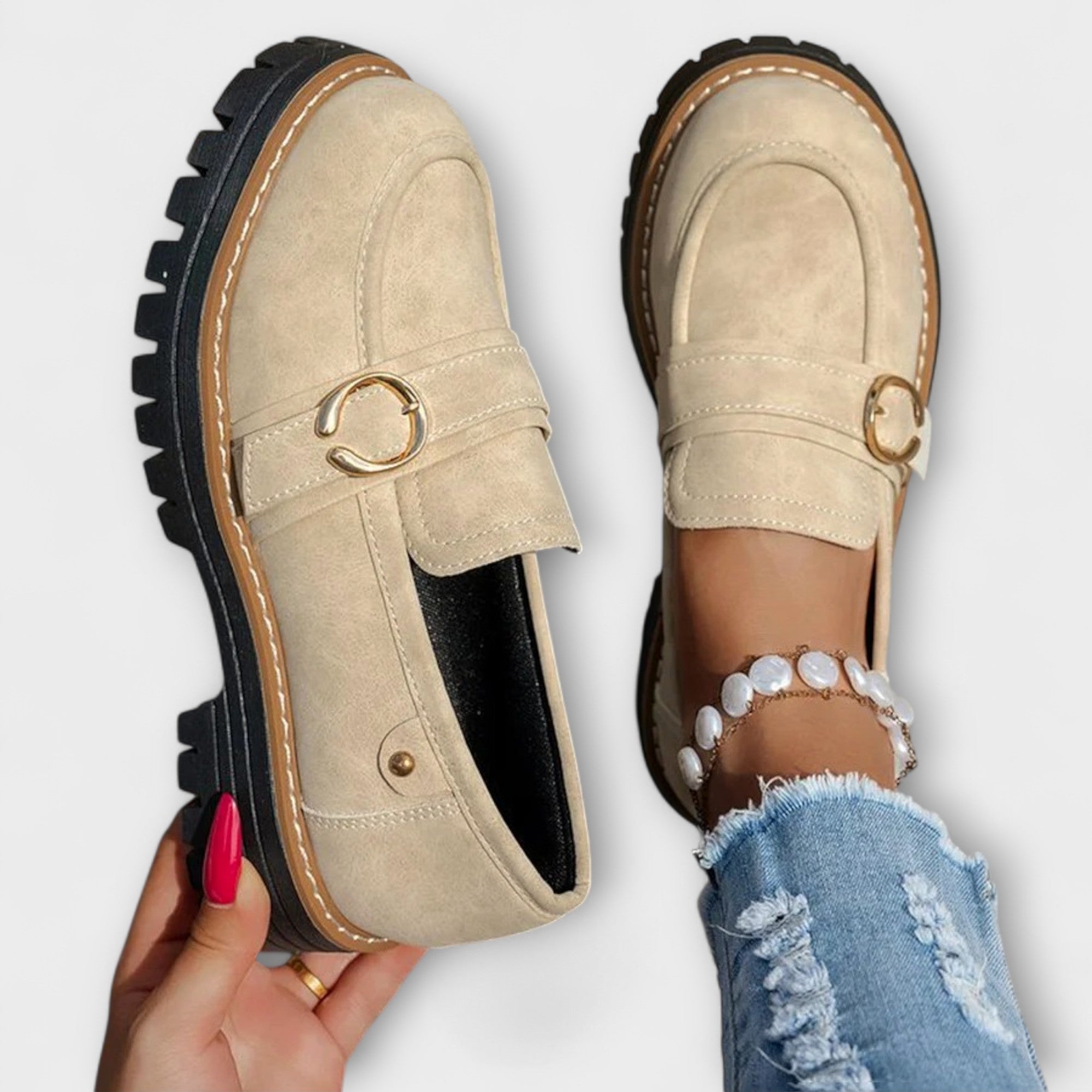 Beige suede moccasin loafers with round toe, metal ring buckle, and thick tread sole