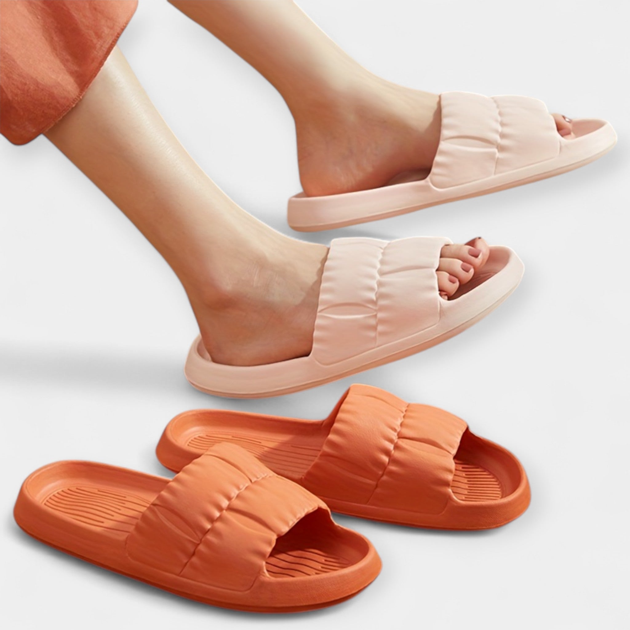 Light pink and orange slide sandals on feet, padded straps and open-toe slides