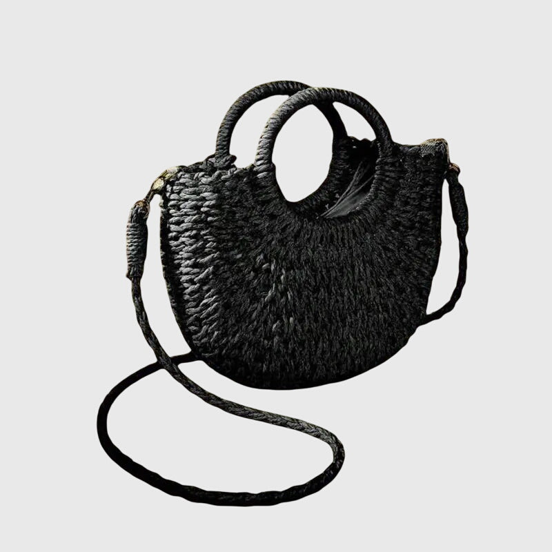 Black woven straw shoulder bag with loop handles and long crossbody strap.