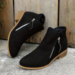 Pair of black suede ankle boots with side zippers and low wooden block heels.