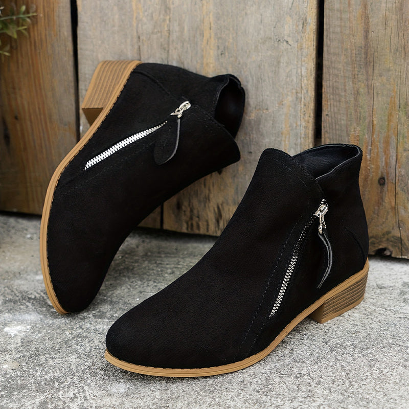 Pair of black suede ankle boots with side zippers and low wooden block heels.