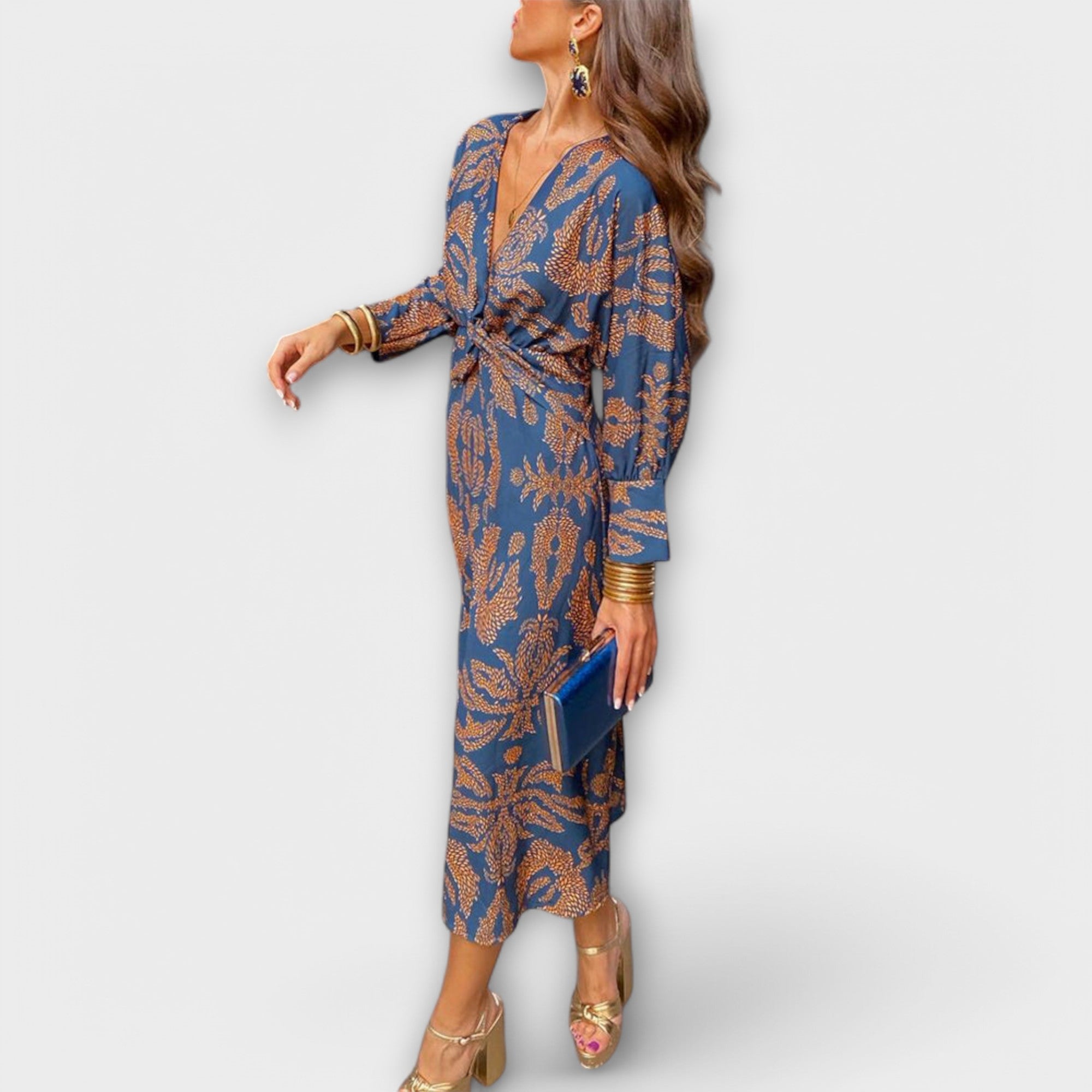 Elegant long-sleeve V-neck dress with blue and gold ornate print, waist tie