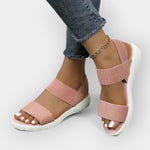 Comfort sandals with wide textured straps, open toe, blush pink upper, white platform sole.