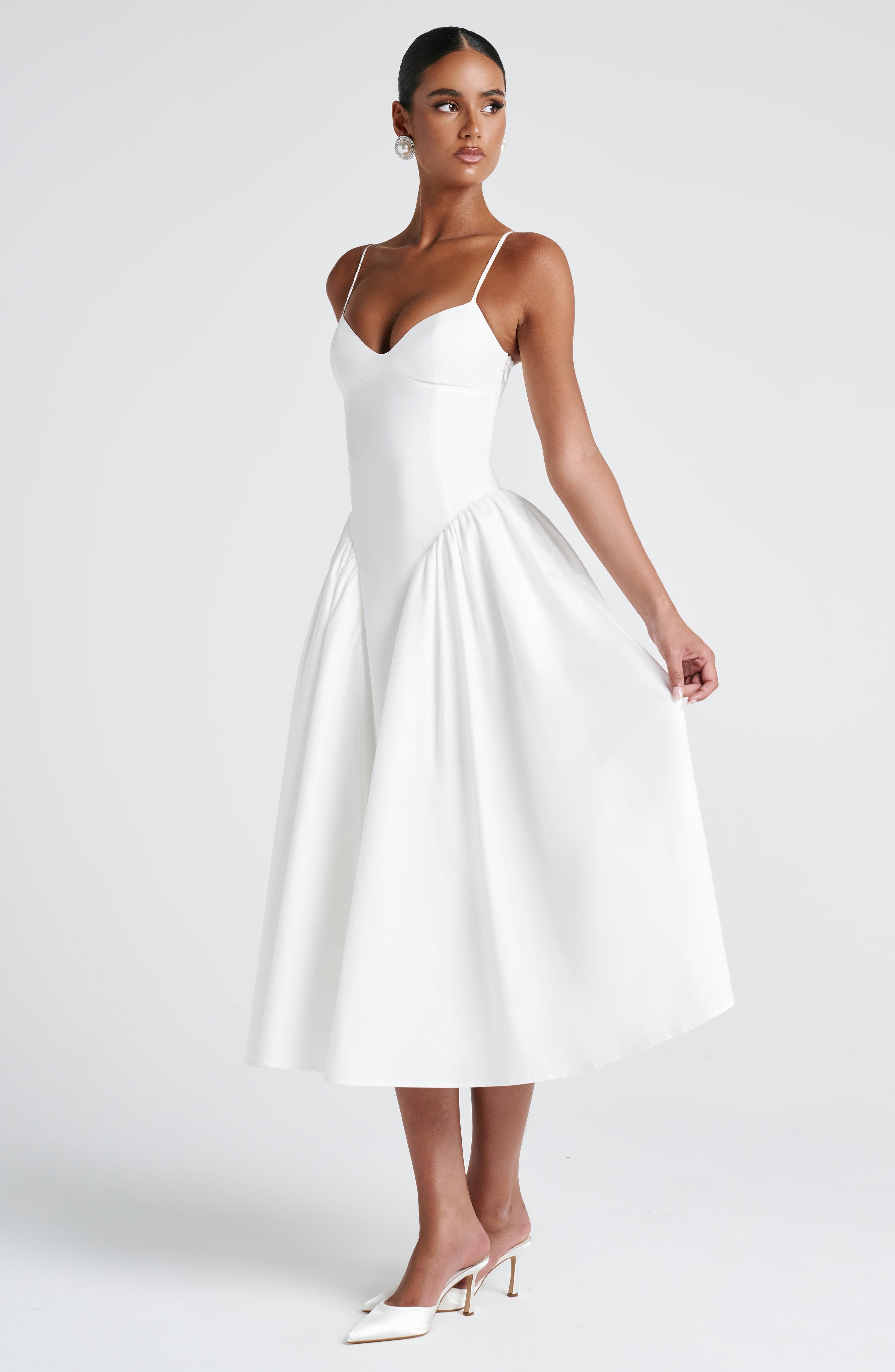 Women’s white midi dress with thin straps, fitted waist, and full flared skirt