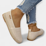 Beige espadrille-style slip-on loafers with fabric upper and braided wedge sole