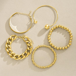 Gold-tone overlapping bracelet set with bead rings, chunky chain links, and thin bangles (5 pieces)